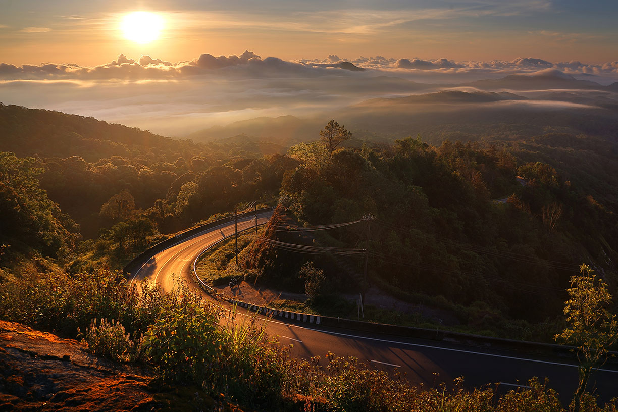Winding road through hills at sunset