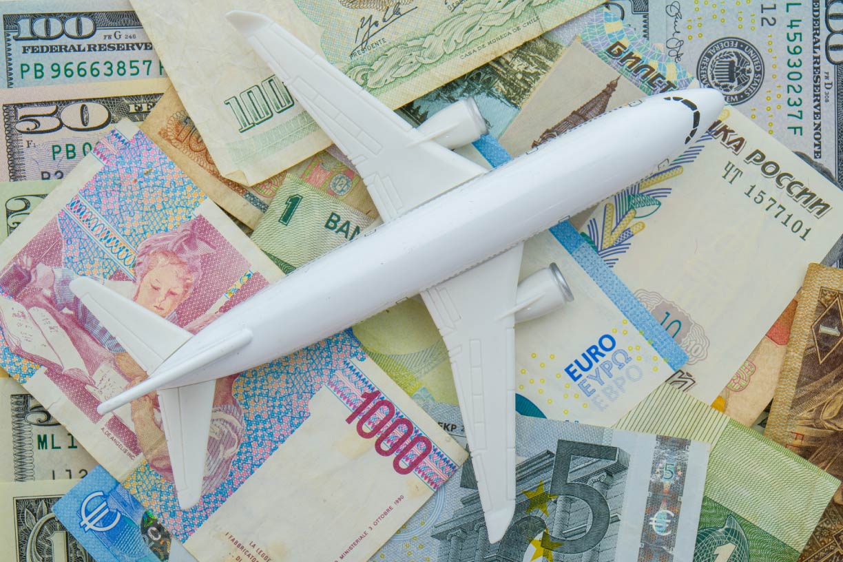 Passenger plane on world currency concept 