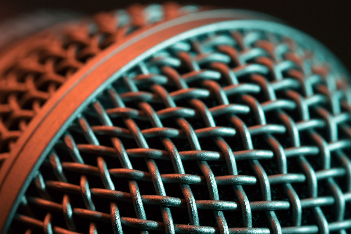 close-up of microphone with peach and teal colored light reflections