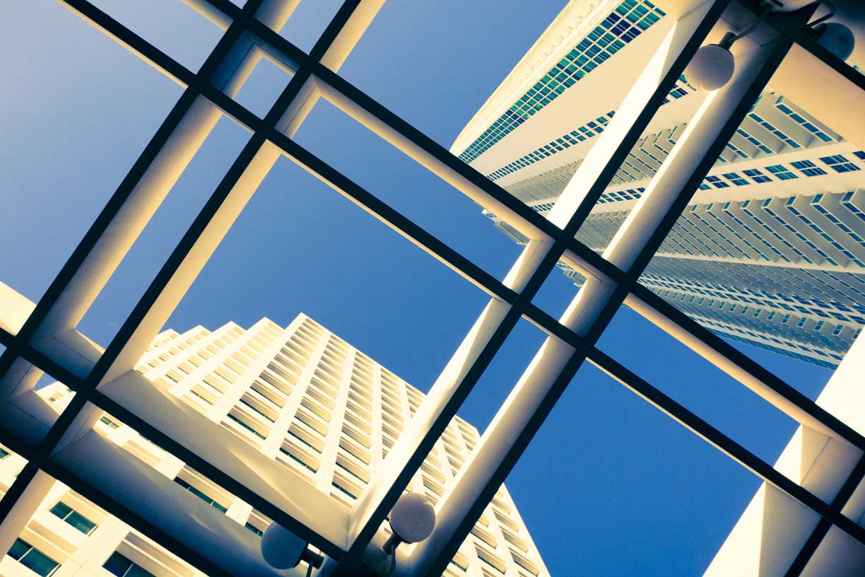 Looking up through glass ceiling wiht high rise buildings