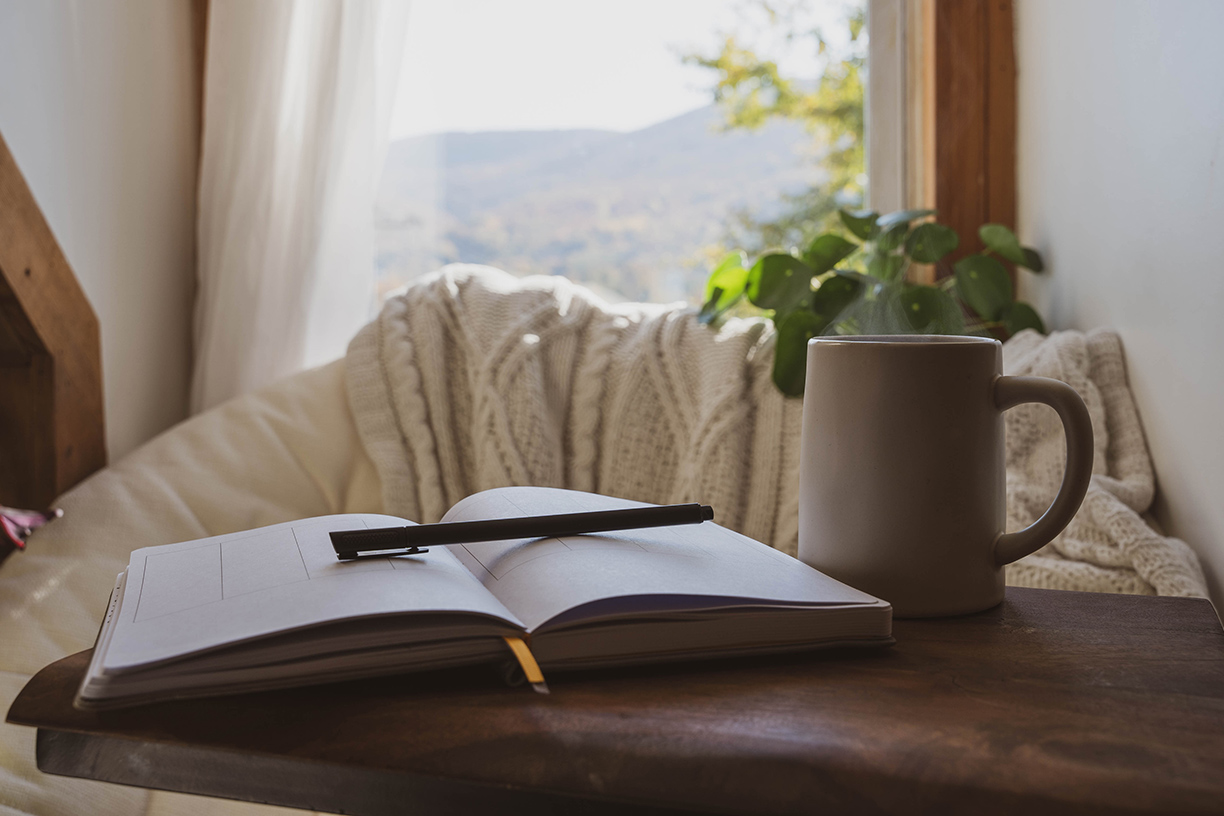 Day planner and coffee mug near window