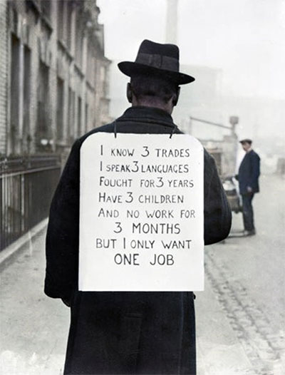 Depression era man on street wears sign on his back that reads 