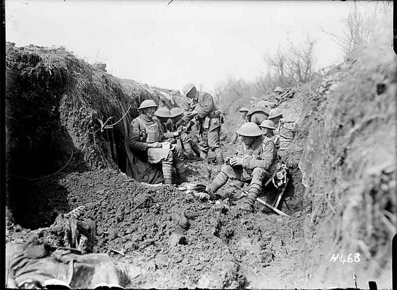 WWI soldiers eat a meal in frontline trench.